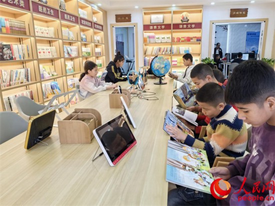 阿依丁庫勒村圖書館內，孩子們正在閱讀。人民網記者 陳新輝攝